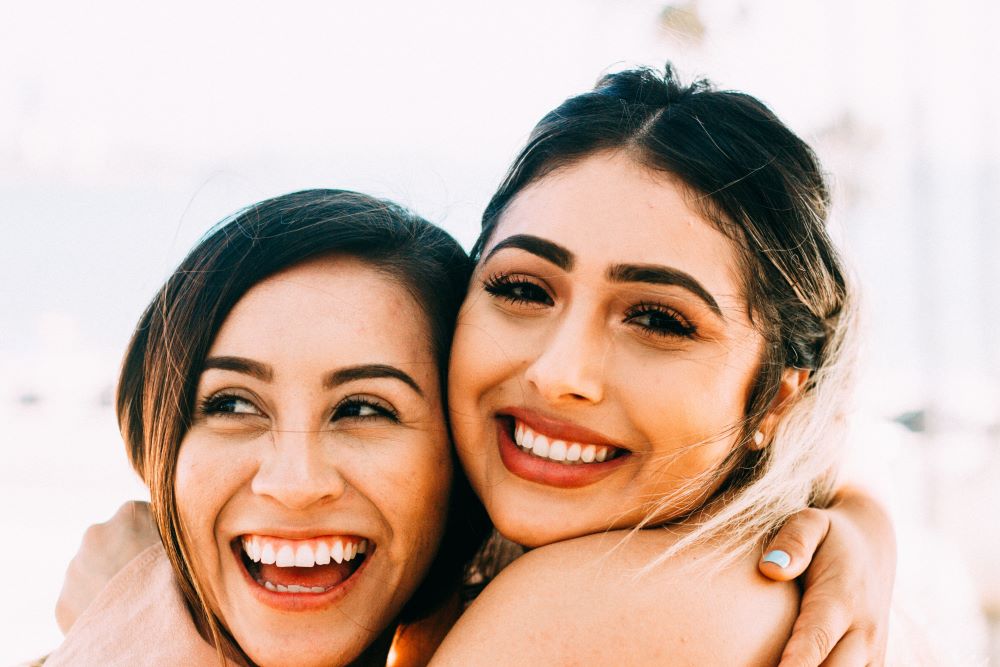 two women holding each other and smiling